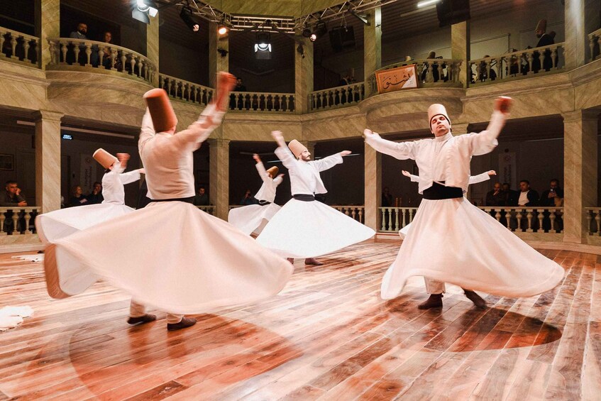 A dance performance in a historic building with marble columns and a wooden floor. 1