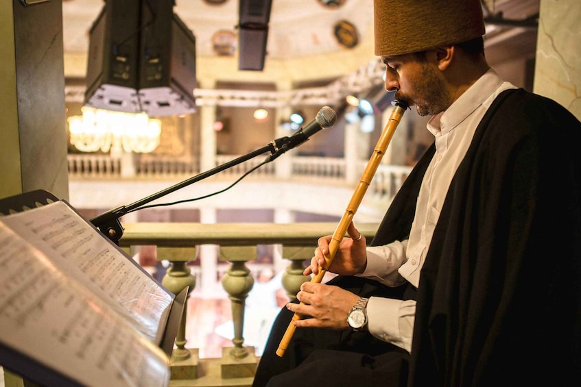 A person playing a flute with sheet music in front of a microphone. 4