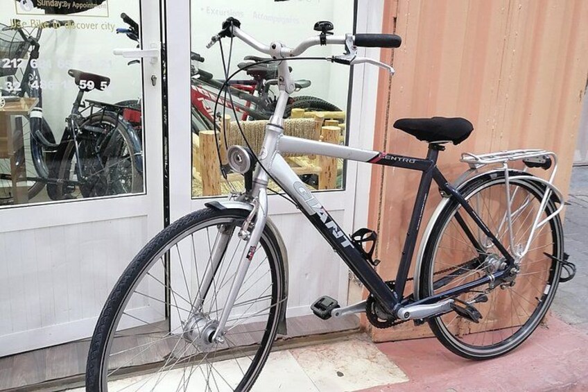 Un vélo noir et blanc est garé devant un magasin dont la porte est en verre. 5
