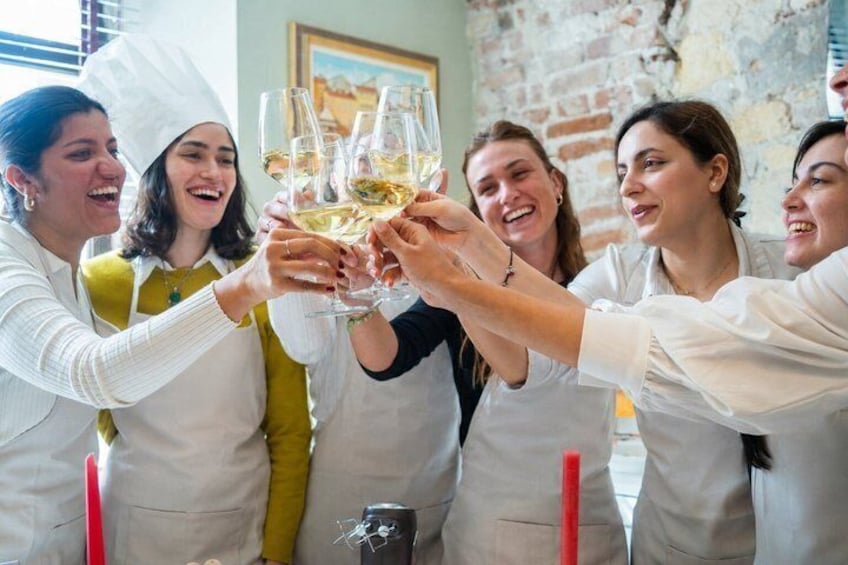 A group of people toasting with champagne glasses in a brick-walled room. 5