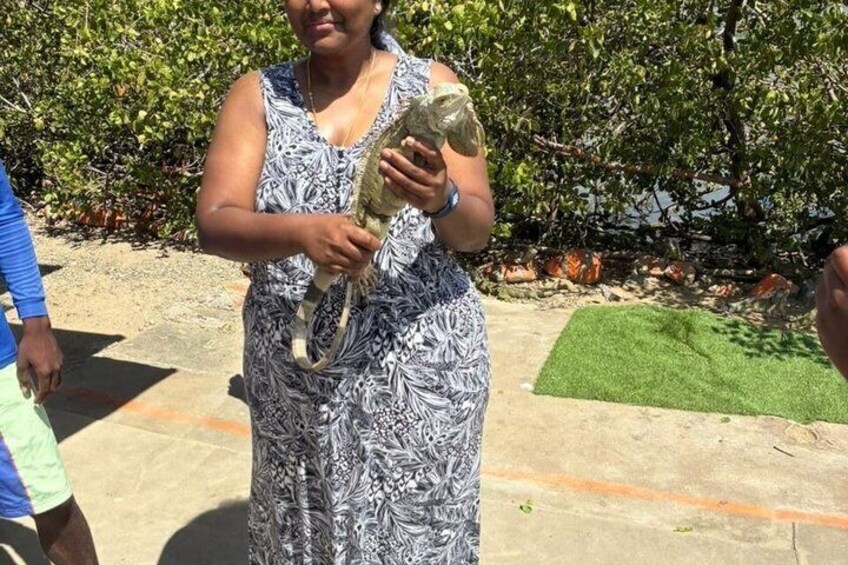 A person holding a large, patterned object outdoors with greenery in the background. 3