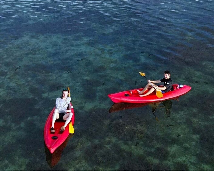 Two people kayaking on a clear body of water. 5