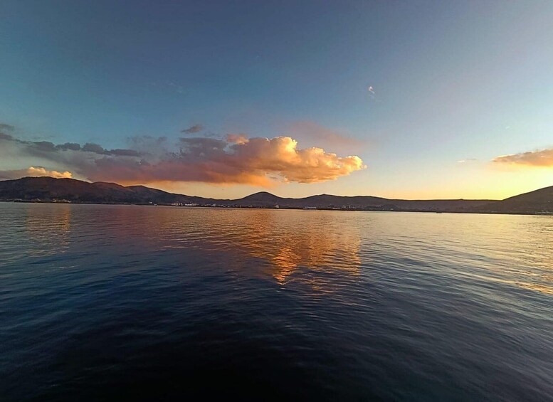 A calm lake with mountains in the background and a sunset sky. 4