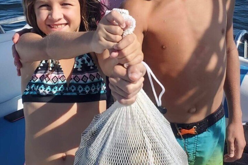 A person holding a net, another person in a bikini, and a boat in the background. 5