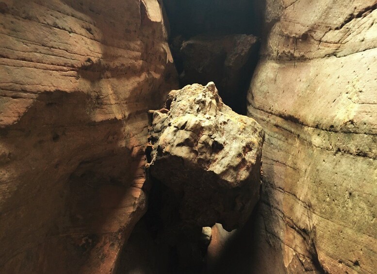 A narrow canyon with a large rock formation in the center. 3