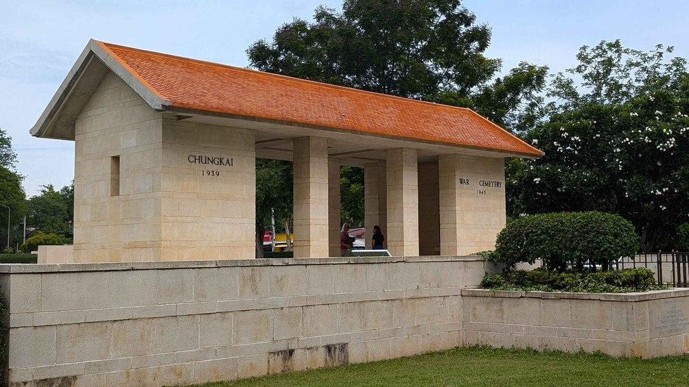 A war cemetery with a covered memorial structure, columns, and inscriptions. 4