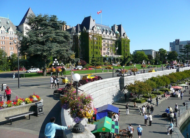 A city square with a historic building, a flag, and a busy street with pedestrians and vehicles. 3