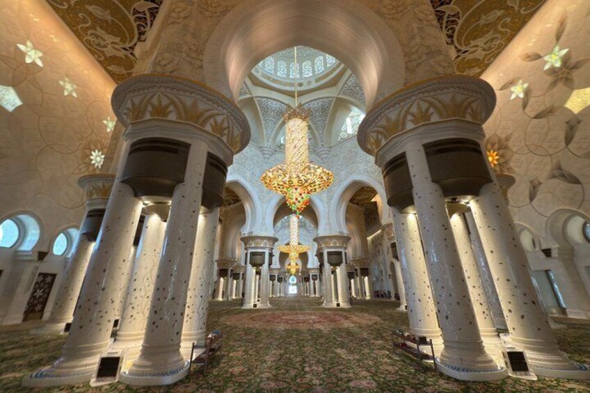 Un intérieur somptueux, orné de colonnes, d’un lustre et de murs aux motifs décoratifs. 1