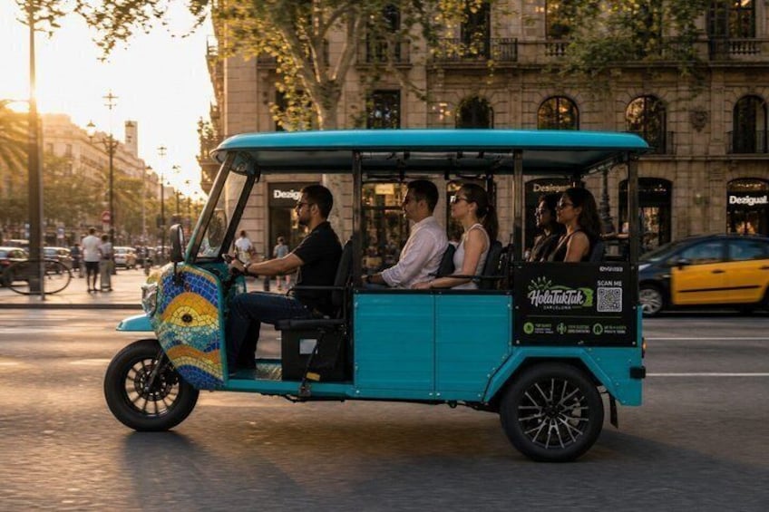 A teal tuk-tuk with passengers on a city street. 5
