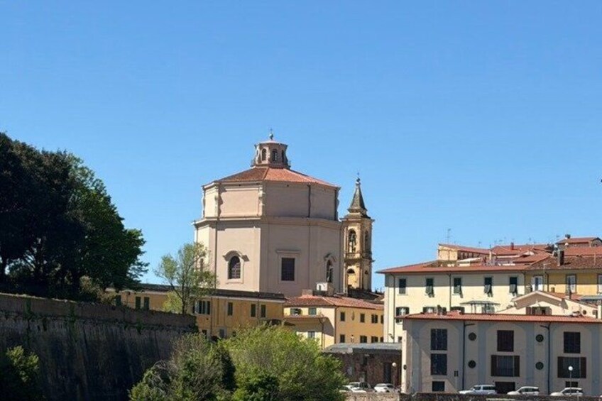 Eine Kirche mit einem Glockenturm, umgeben von Gebäuden mit roten Ziegeldächern. 4