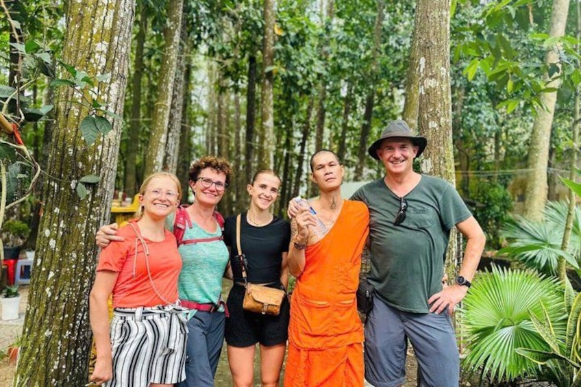 Un grupo de personas de pie en un bosque con árboles altos y follaje. 1
