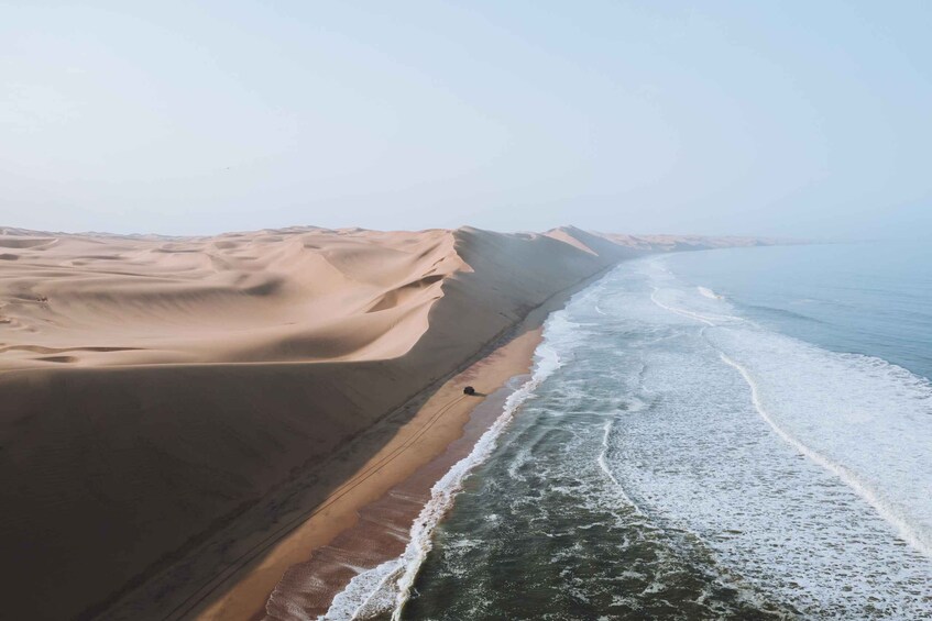 A beach with sand dunes and waves. 2