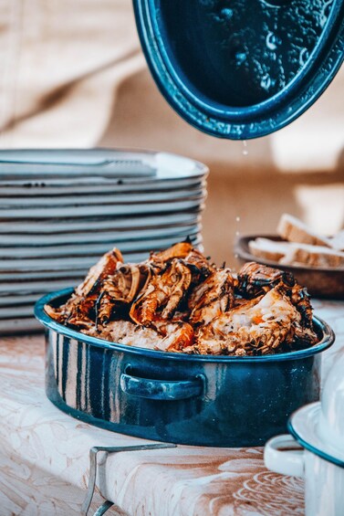 A blue pot with grilled food on a table. 4