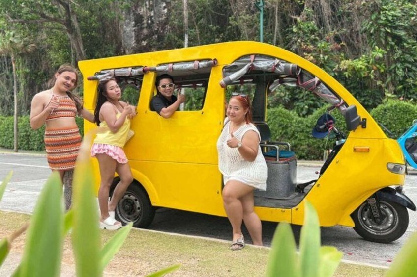 Un turismo automático amarillo estacionado al borde de la carretera, con gente a su alrededor. 2