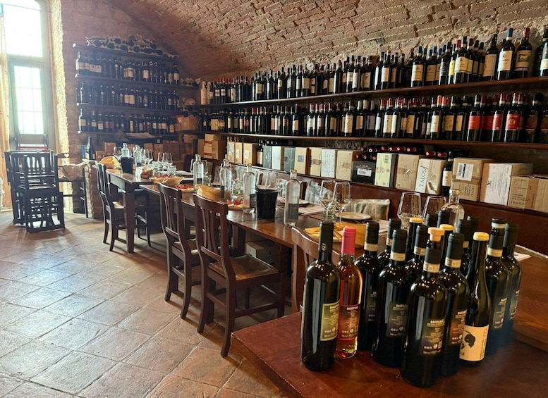 A wine cellar with shelves of bottles and a bar area with chairs and glasses. 4
