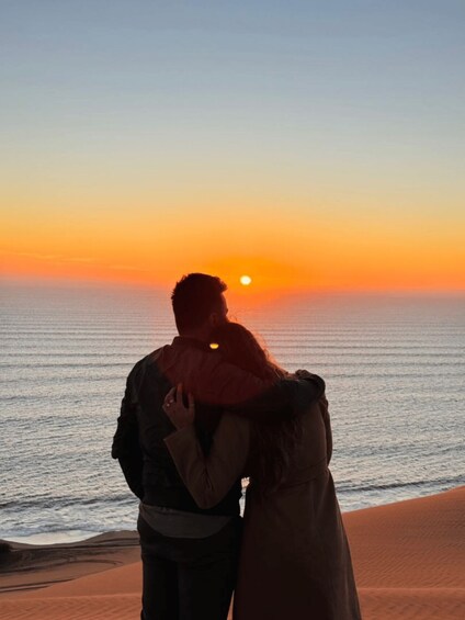 Two people embracing at sunset by the ocean. 4