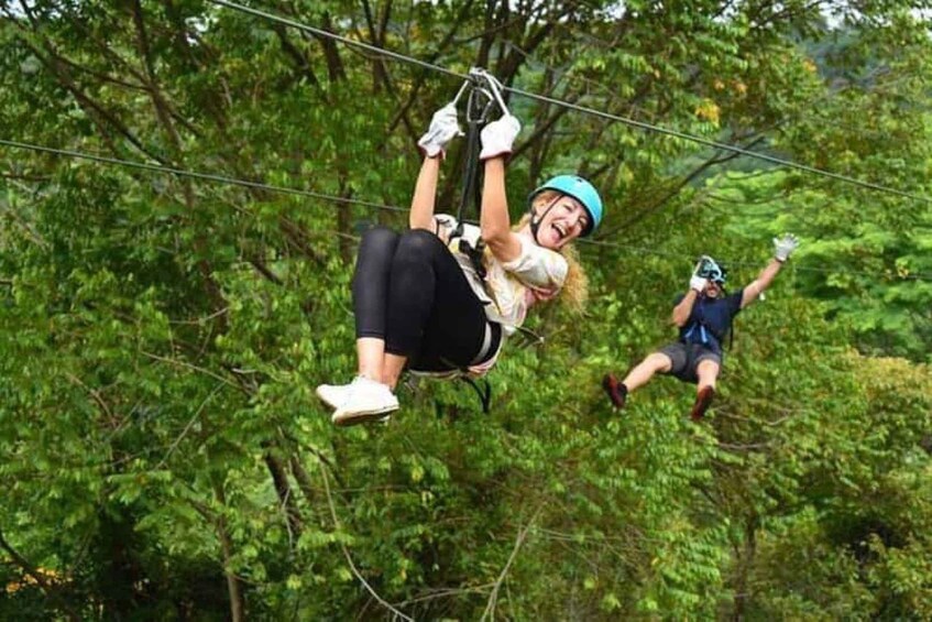Two people zip-lining through a forest. 5