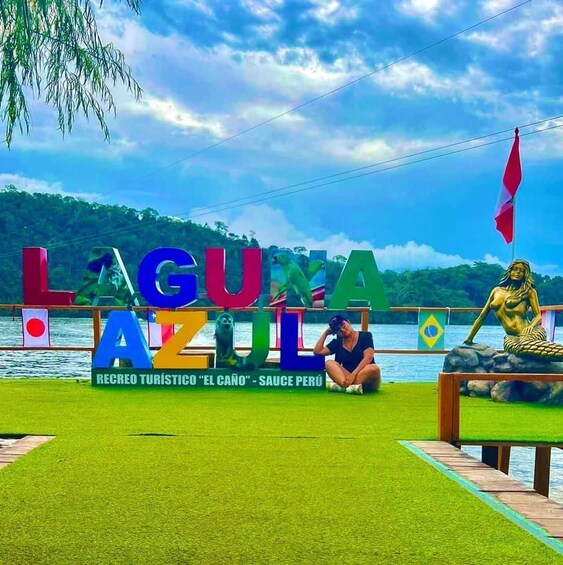 Et skilt med farverige bogstaver, der staver 'LAGUNA AZUL', og en statue af en havfrue. 2