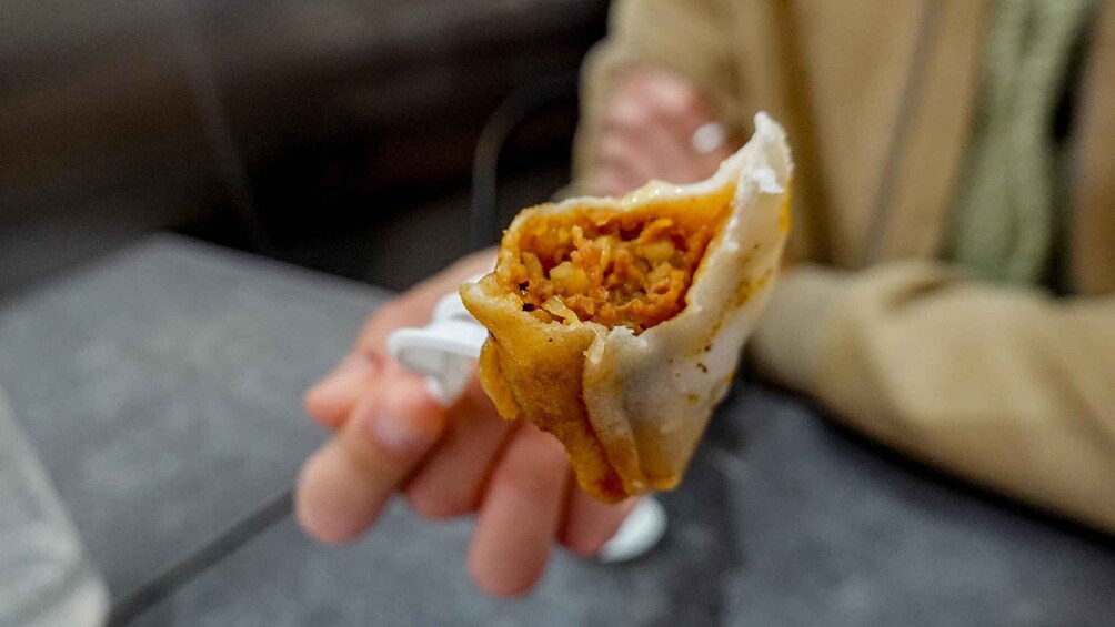 A person holding a half-eaten burrito. 1