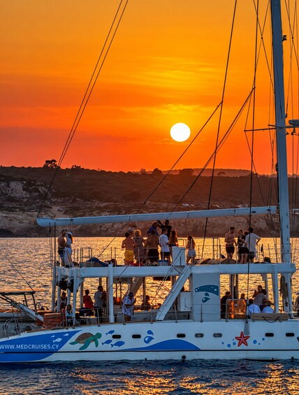 A boat with people on deck during sunset. 3