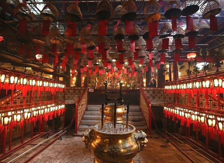 A temple interior with red lanterns, incense burners, and a staircase leading to a central altar. 2