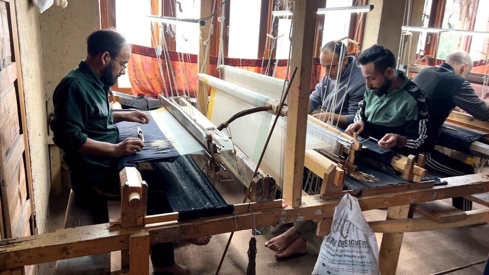 A group of people engaged in weaving on traditional looms. 4