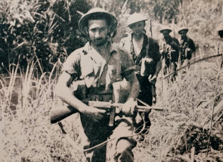 A group of soldiers in a field with one leading and others following. 4