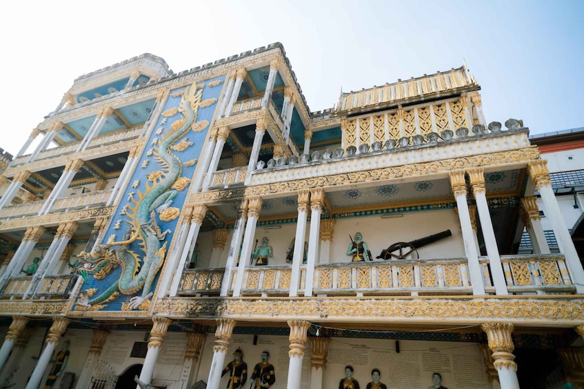 A multi-tiered building with ornate blue and gold decorations, statues, and columns. 3