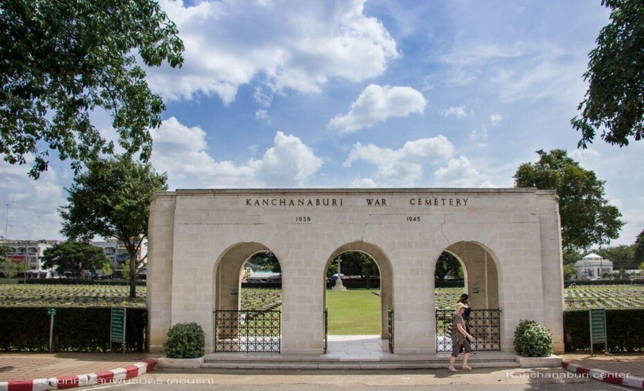 A war cemetery with three arches and a clear sky. 3