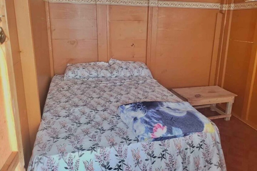 A wooden bed with a floral bedspread and a decorative pillow. 5