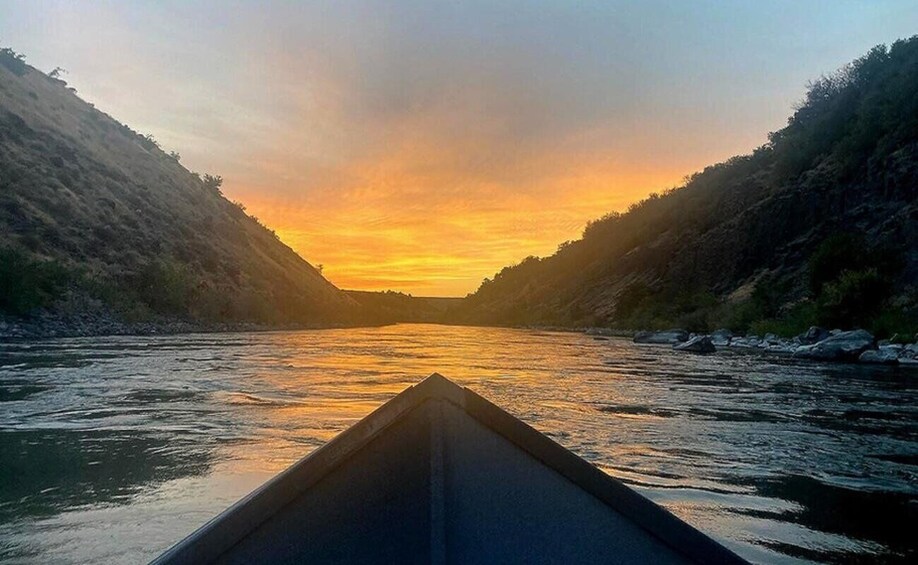 A river at sunset with a canoe in the foreground. 4