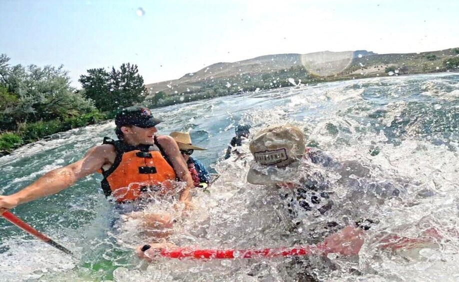 A person in a kayak navigating a river with splashes around them. 5