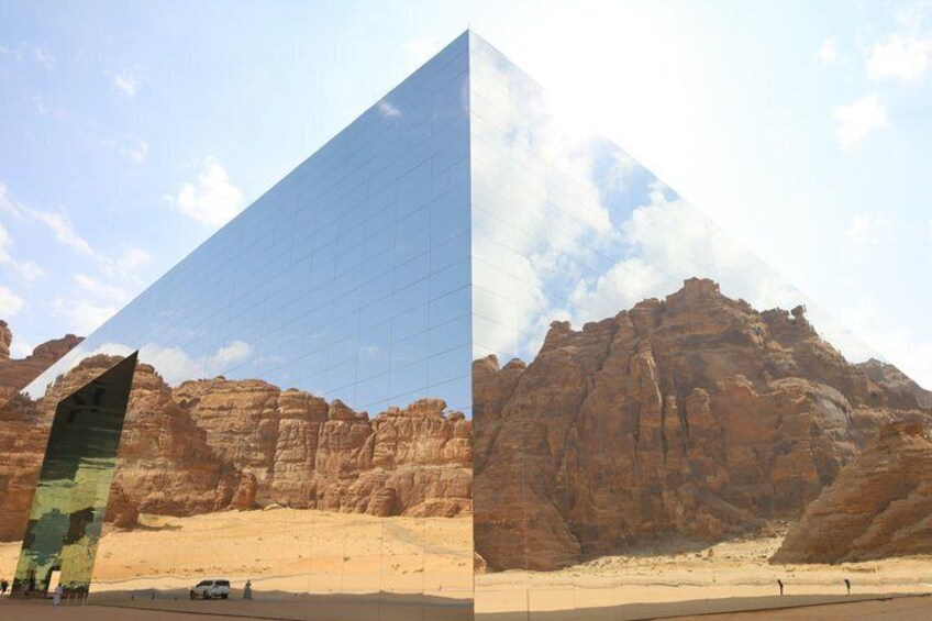 A desert landscape with a large pyramid-like structure and rocky formations. 4