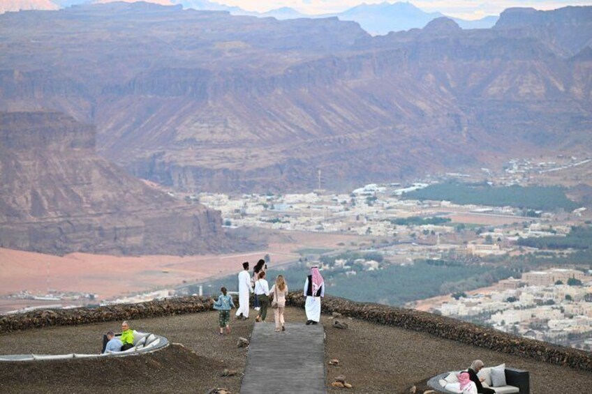 A group of people on a rocky overlook with a canyon view. 3