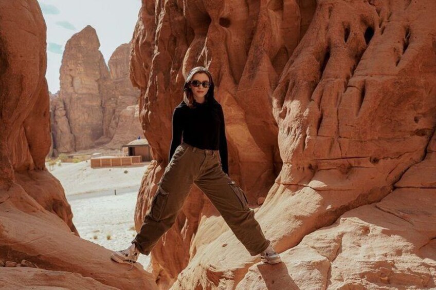 A person standing in a canyon with red rock formations. 5