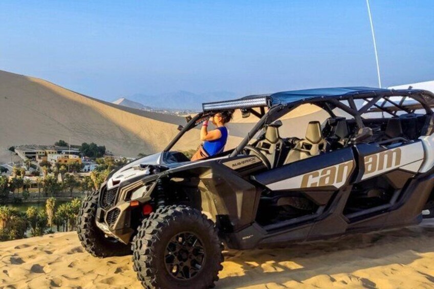 En Can-Am-terrängbil parkerad på en sanddyn med ett ökenlandskap i bakgrunden. 5