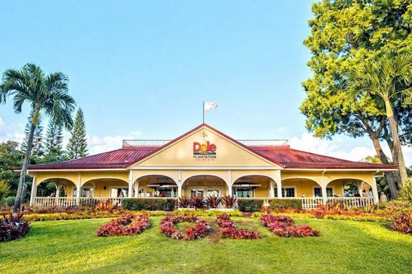 A yellow building with a red roof, surrounded by well-maintained gardens and palm trees. 5