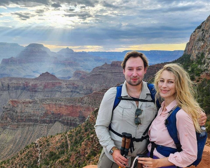A couple standing on a mountain with a canyon in the background. 4