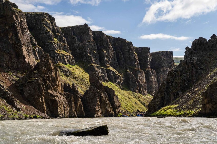A river flowing through a canyon with steep cliffs and a clear sky. 4