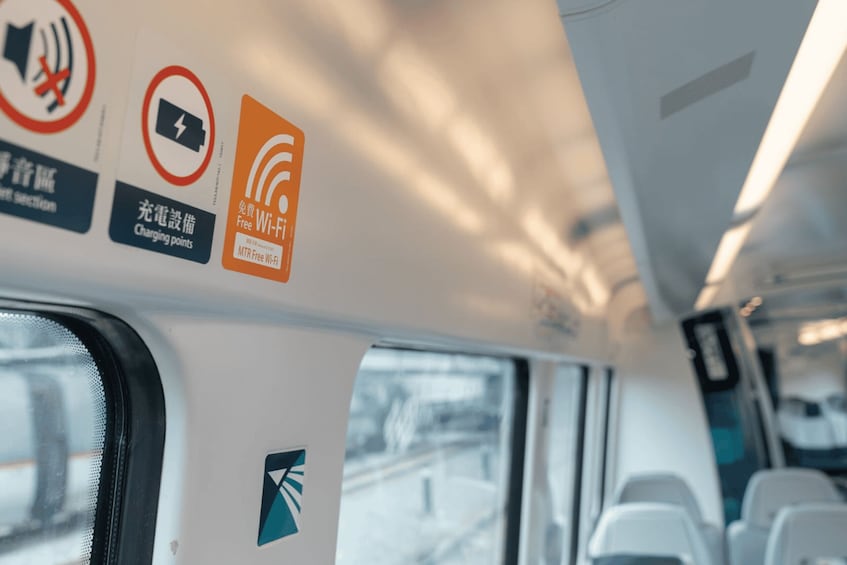 A bus interior with Wi-Fi and charging point signs. 3