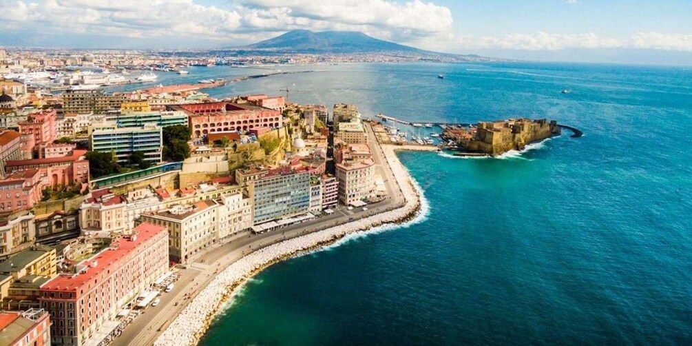A coastal cityscape with a prominent fort, a mountain in the distance, and a harbor with boats. 5