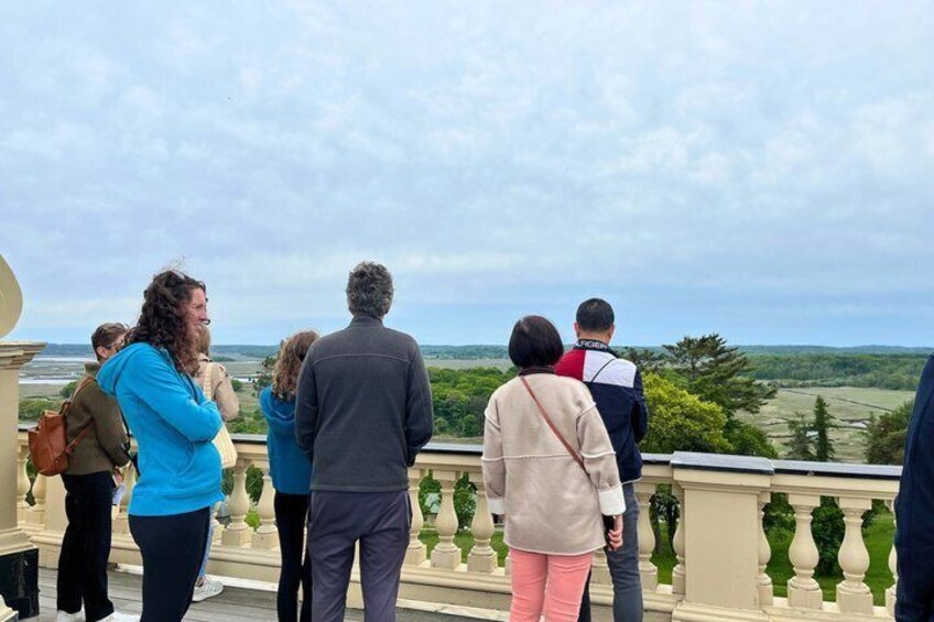 A group of people standing on a balcony overlooking a landscape. 4