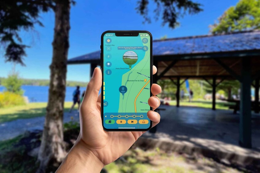A hand holding a smartphone with a map application displaying a park with a lake, a pavilion, and a marked path. 5
