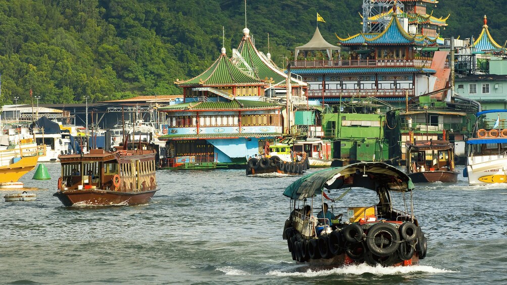 A traditional boat with a covered canopy, a green-roofed temple, and a bustling harbor with various boats. 1