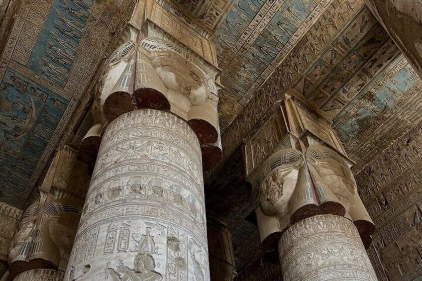 Oude Egyptische kolommen met hiërogliefen en een plafond met gedetailleerde fresco's. 1