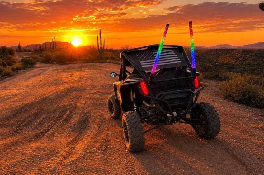 A quad bike on a dirt road with a sunset in the background. 1