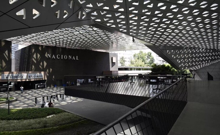 A modern architectural structure with a geometric pattern on the ceiling and a large sign reading 'NATIONAL.' 2
