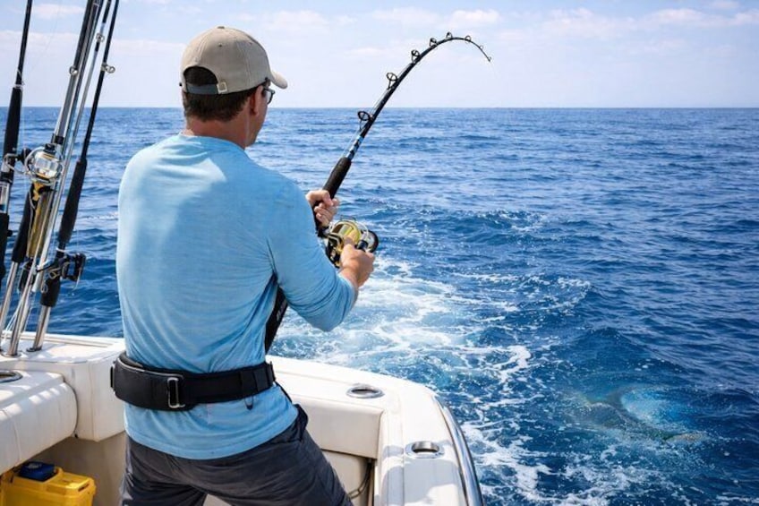 Un homme est en train de pêcher sur un bateau, en pleine mer. 1