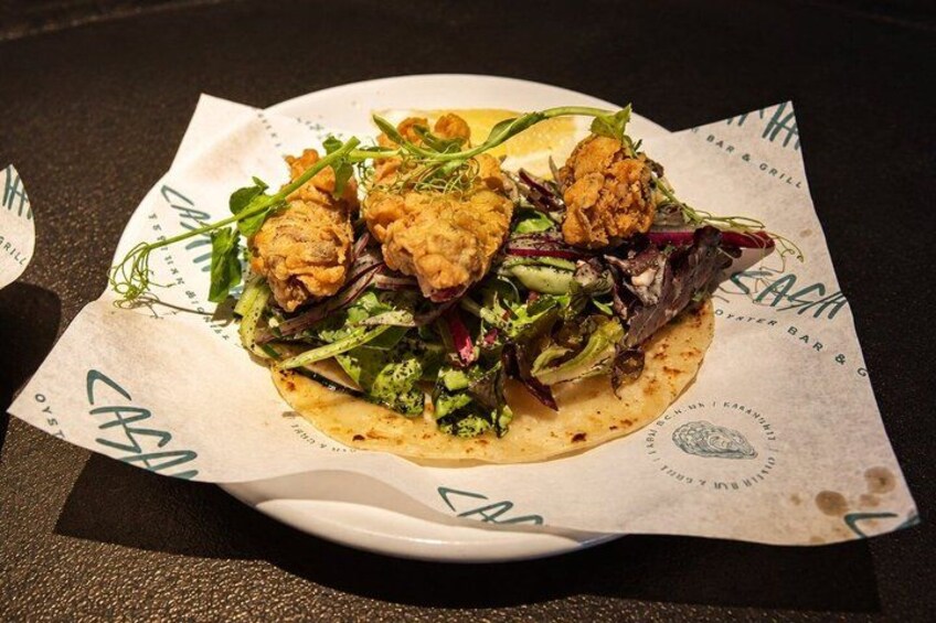 A plate of food with a paper wrapper, a logo, and some text. 3