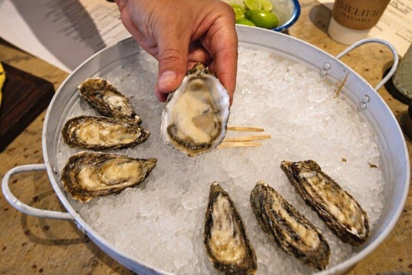 A hand holding an oyster over ice. 4